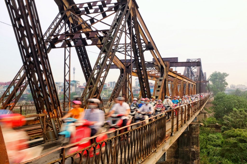 Photo a very busy Long Bien Bridge at rush hour, a blur of scooters