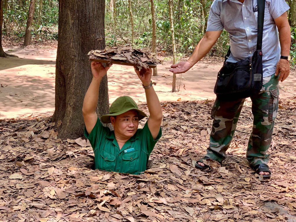 A Vietnamese man entering one of the Cu Chi Tunnels - here you can see his upper body. 