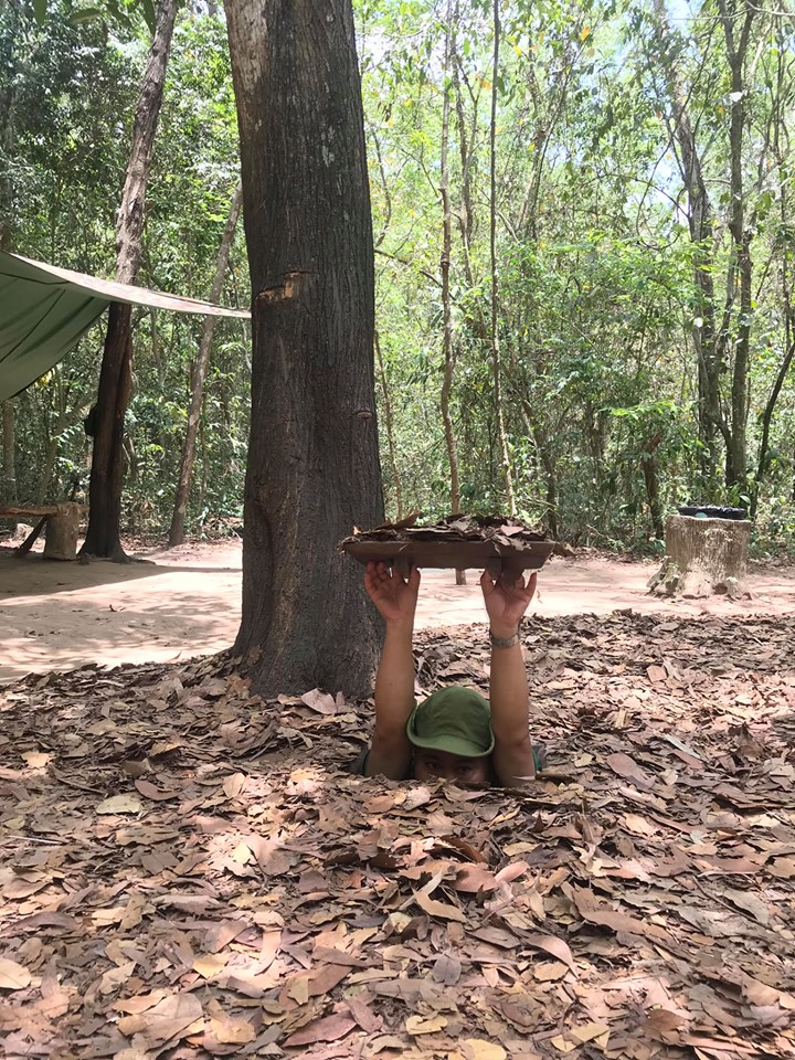 A Vietnamese man entering one of the Cu Chi Tunnels - he is dropping down