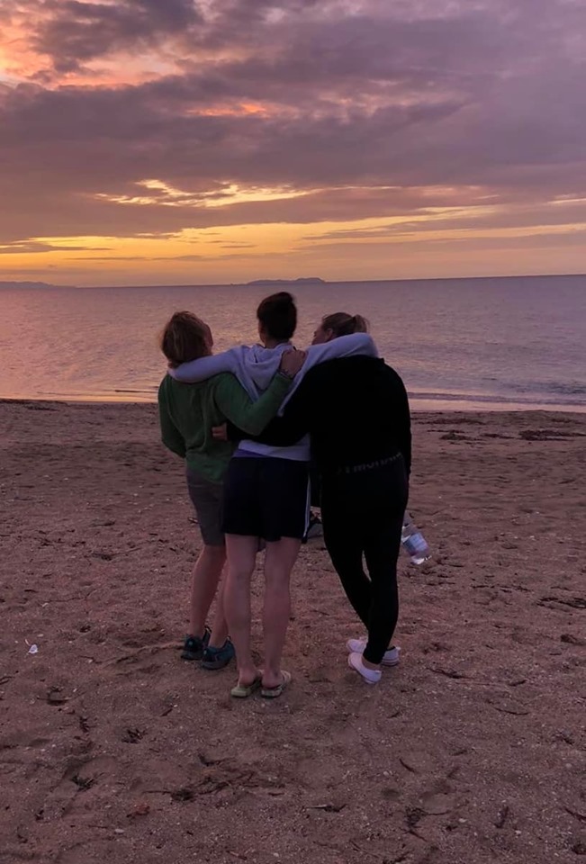 3 friends looking over the sea at sunset laughing, My best memory from the yoga retreat. 