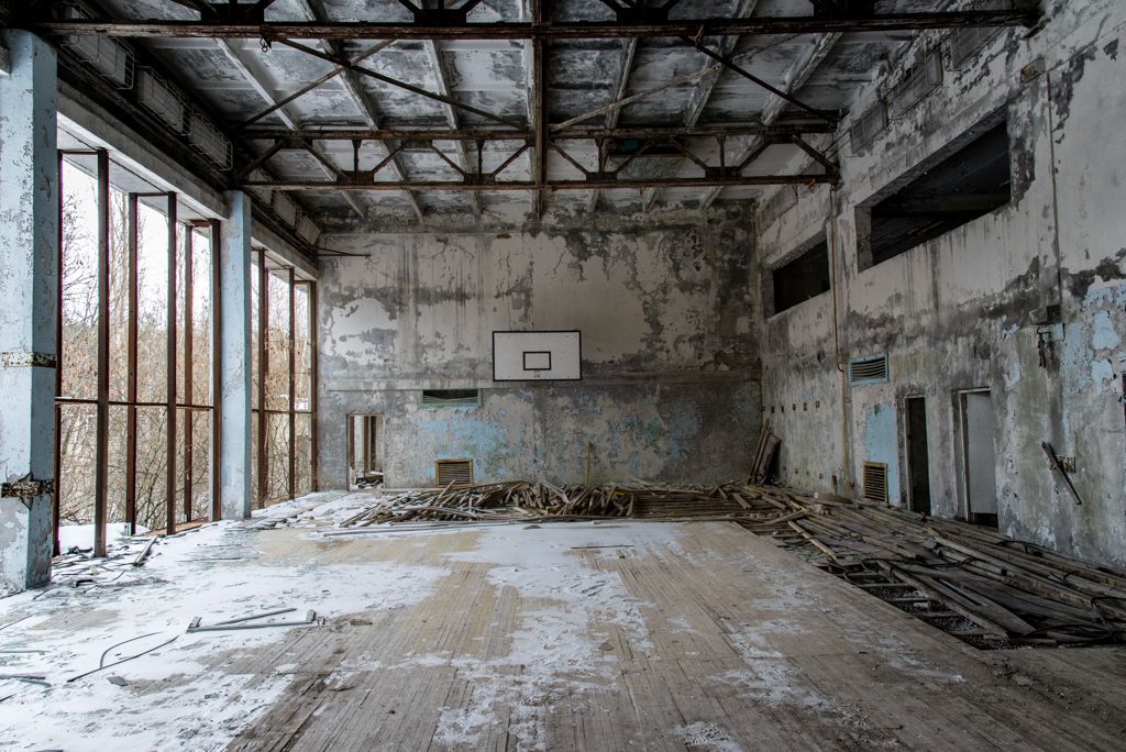 Image of a decaying indoor basket ball pitch in the city of Prypiat. 