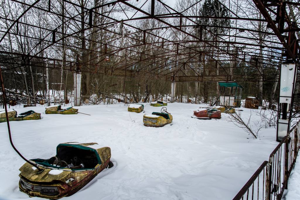 Image of the abandoned dodgems cars in their rusty enclosure. 