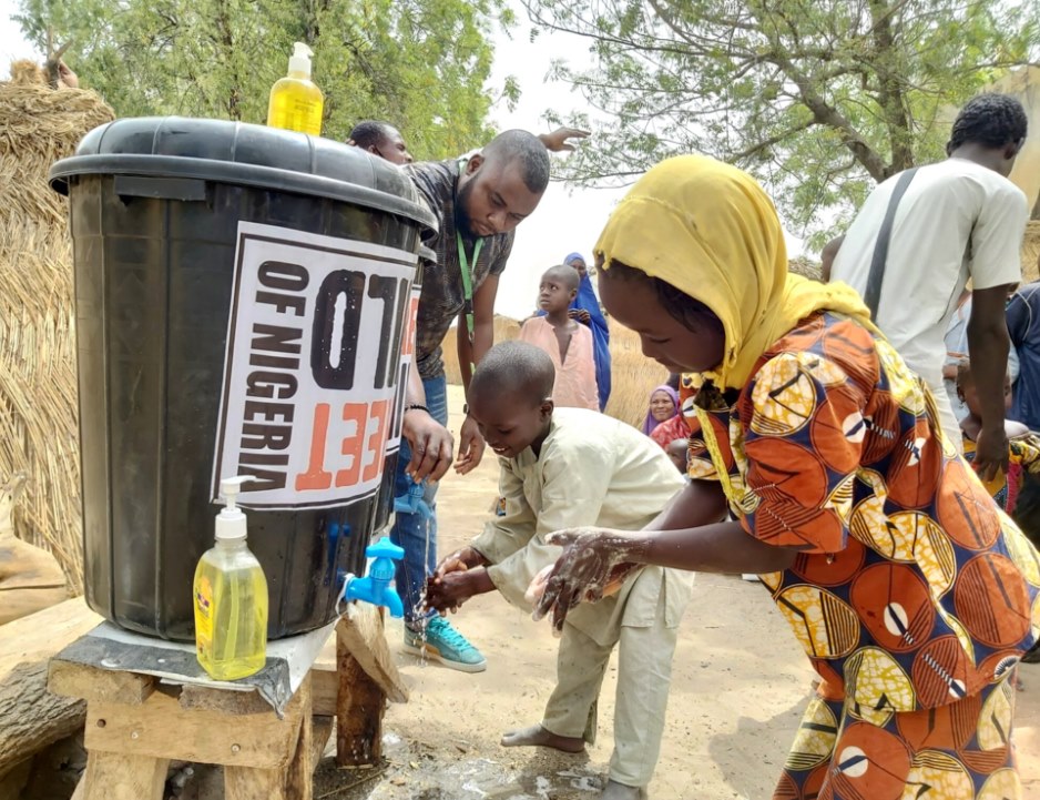 Two kids making use of Street Childs hand washing station