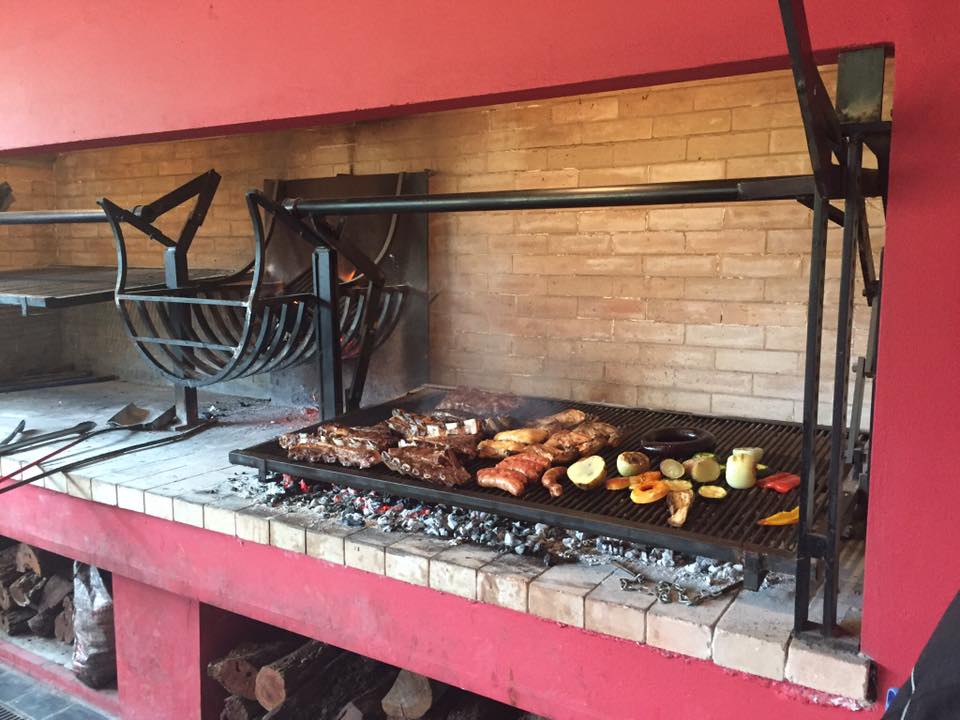 Photo of a grill with meat and veg on it