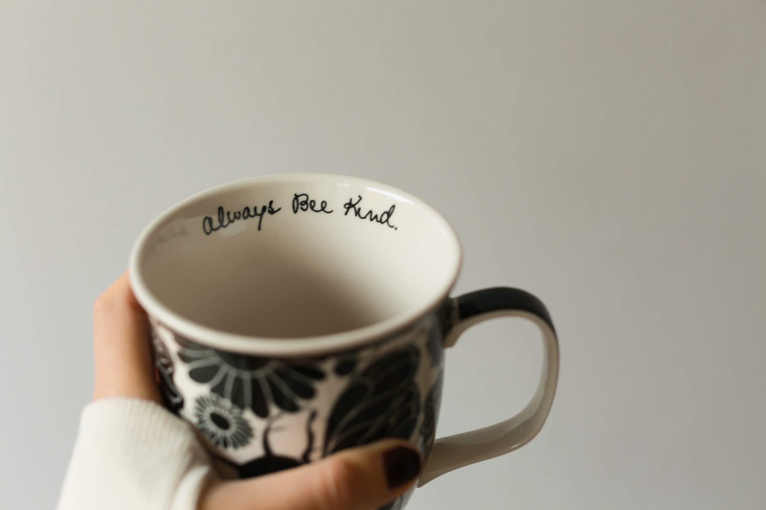 Image of a mug being held that says always be kind