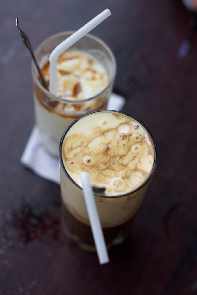 A top thing to do in Hanoi is to enjoy their creamy egg coffe! Photo of two mugs of the extreely frothy egg coffee. One of the Top 9 things to do in Hanoi. 