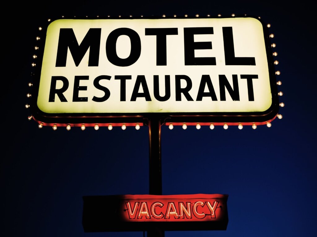 Brightly lit up sign at night that says Motel - Resturant