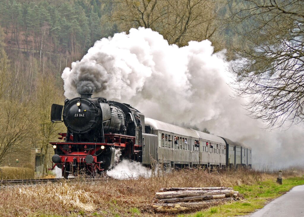 Steam train heading towards the camera, steam billowing into the air