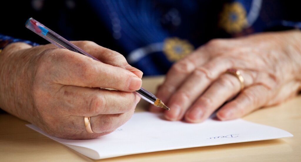 One of the things we can do to help Ukraine is write to our MPs. This is a photo of an old persons hands writing a letter