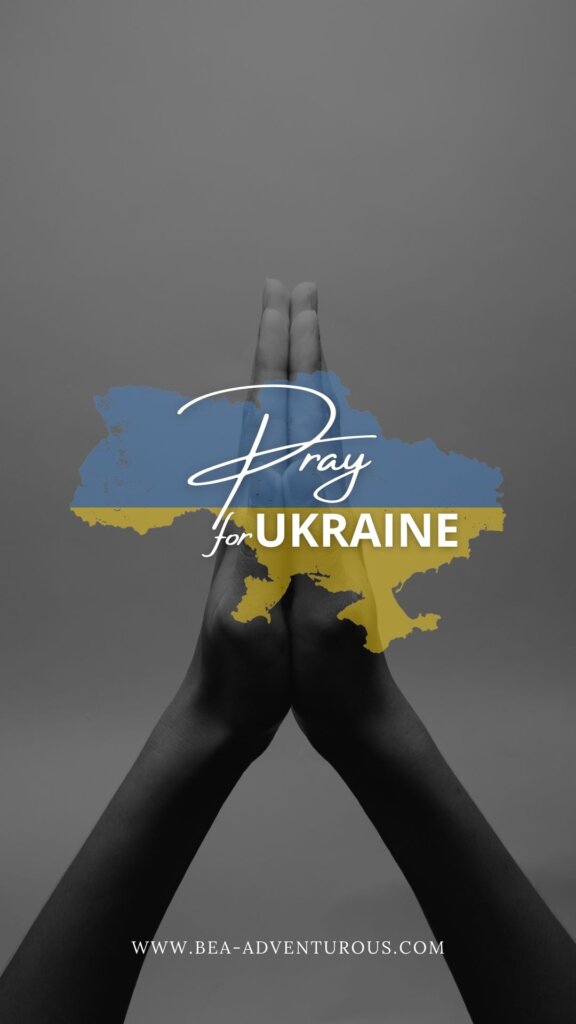 Two hands in prayer with the Ukrainian flag/outline of the country over it and the words Pray for Ukraine. 