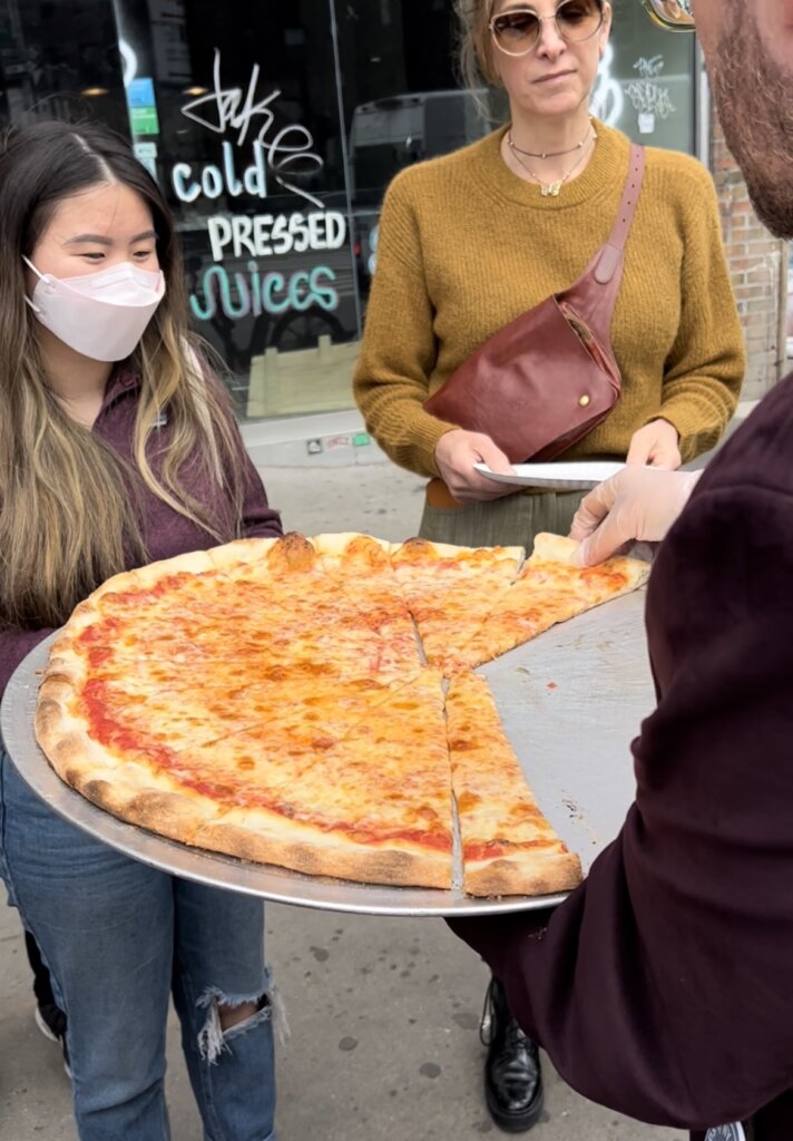 Two ladies eagerly awaiting a slice of Joe's pizza