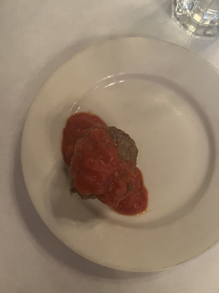 A meat ball with tomato sauce on it