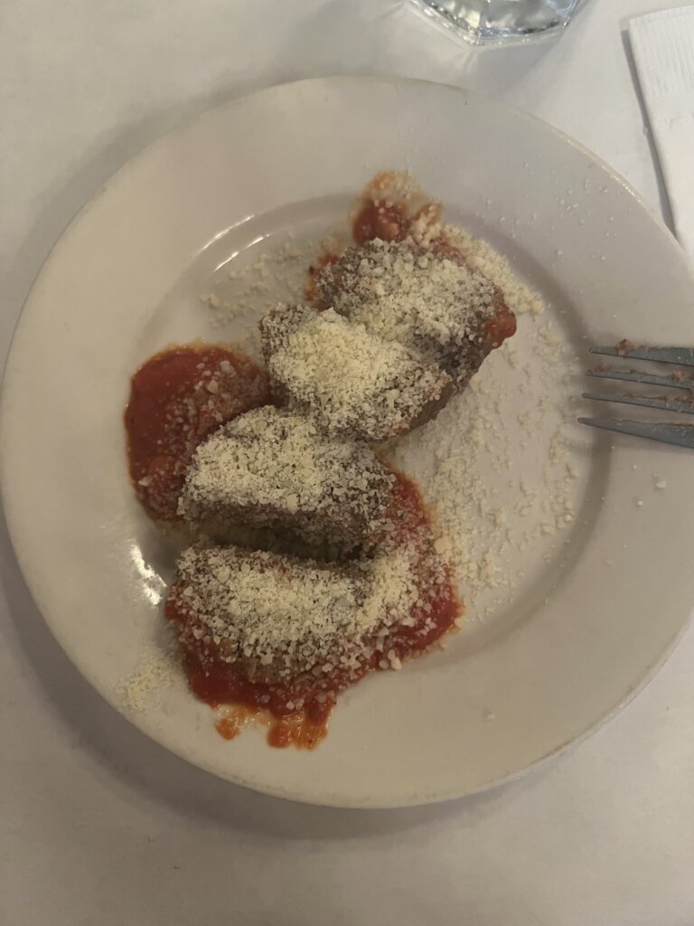 Same meatball cut into 4 and covered in parmesan cheese