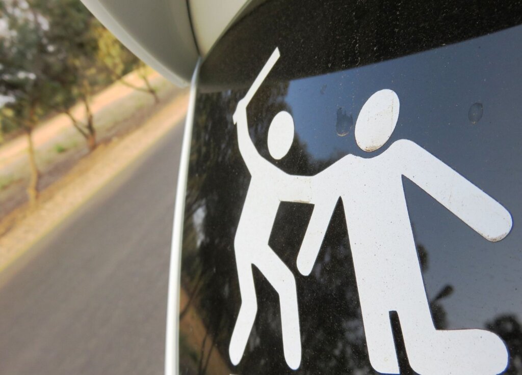 A sticker showing one stick man beating another, to signify road rage