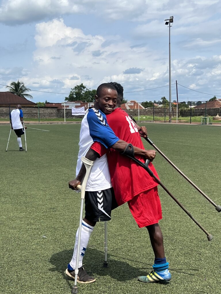 Two civil war amputees, hugging at the end of a football match