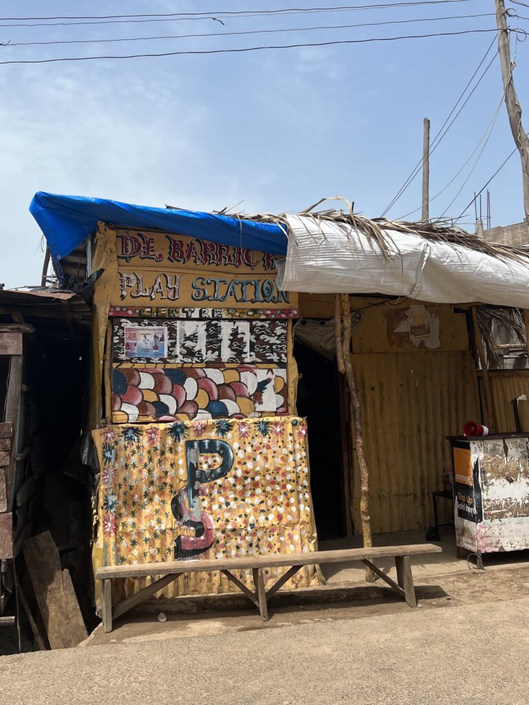 A small woodden shack that reads Play Station. Kids can pay to play on play stations here since it isn't something they'd have at home