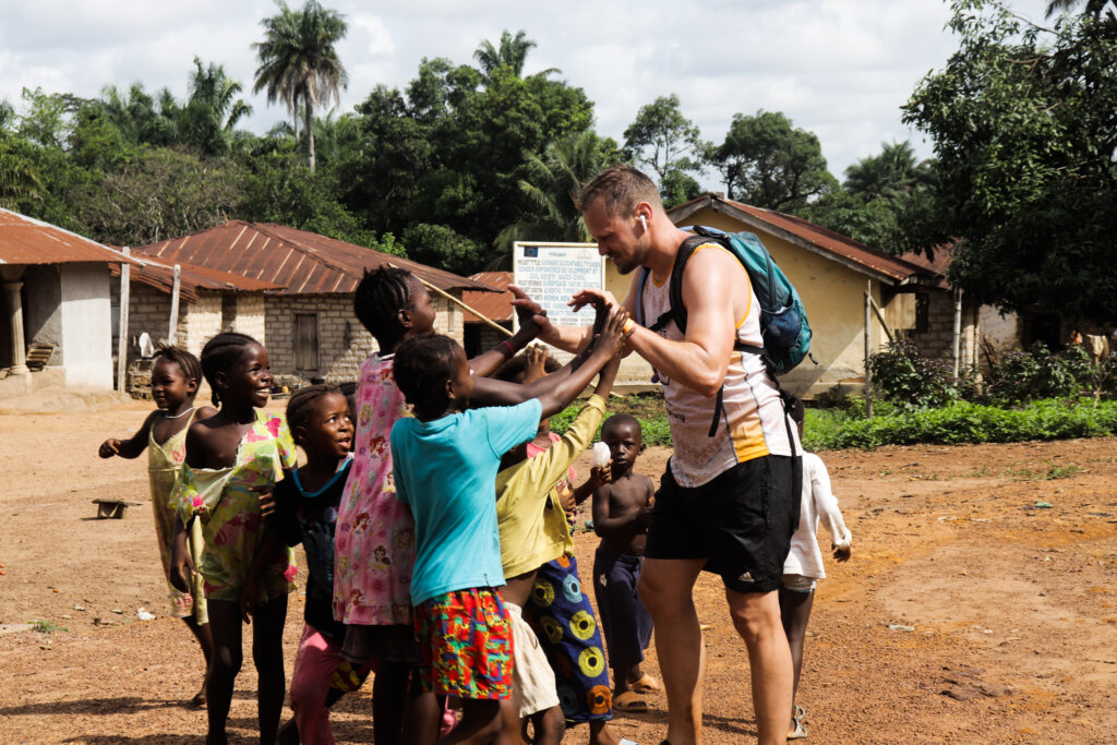 One of the Street Child runners surrounded by kids, all eager to say hello