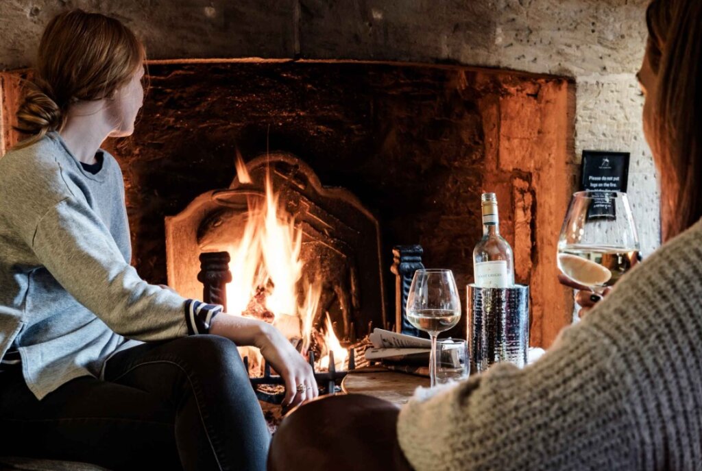 Two ladies sitting by the fire at the Lamb Inn in Burford