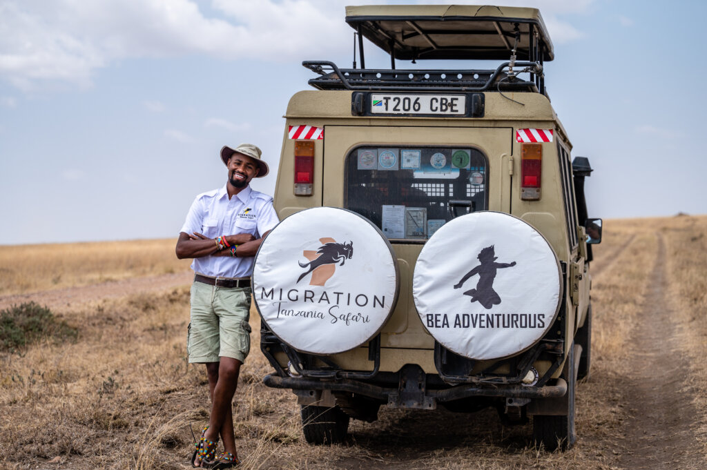 A smiling Malaki standing next to his safari truck