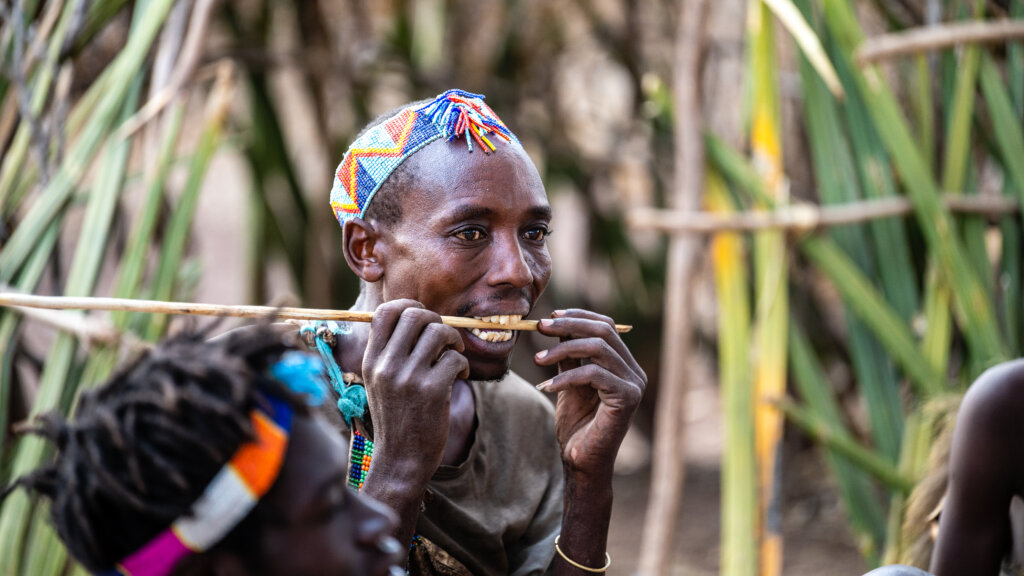 A man straightens the arrow with his teeth