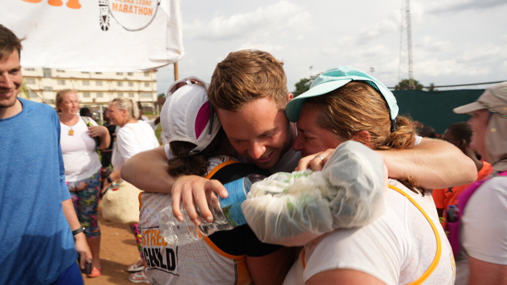 Pete Coopah giving a much deserved hug to two finishers