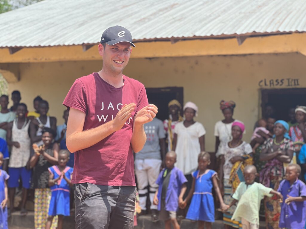 Street Child Sierra Leone marathon runner stands in the middle of a circle of kids clapping