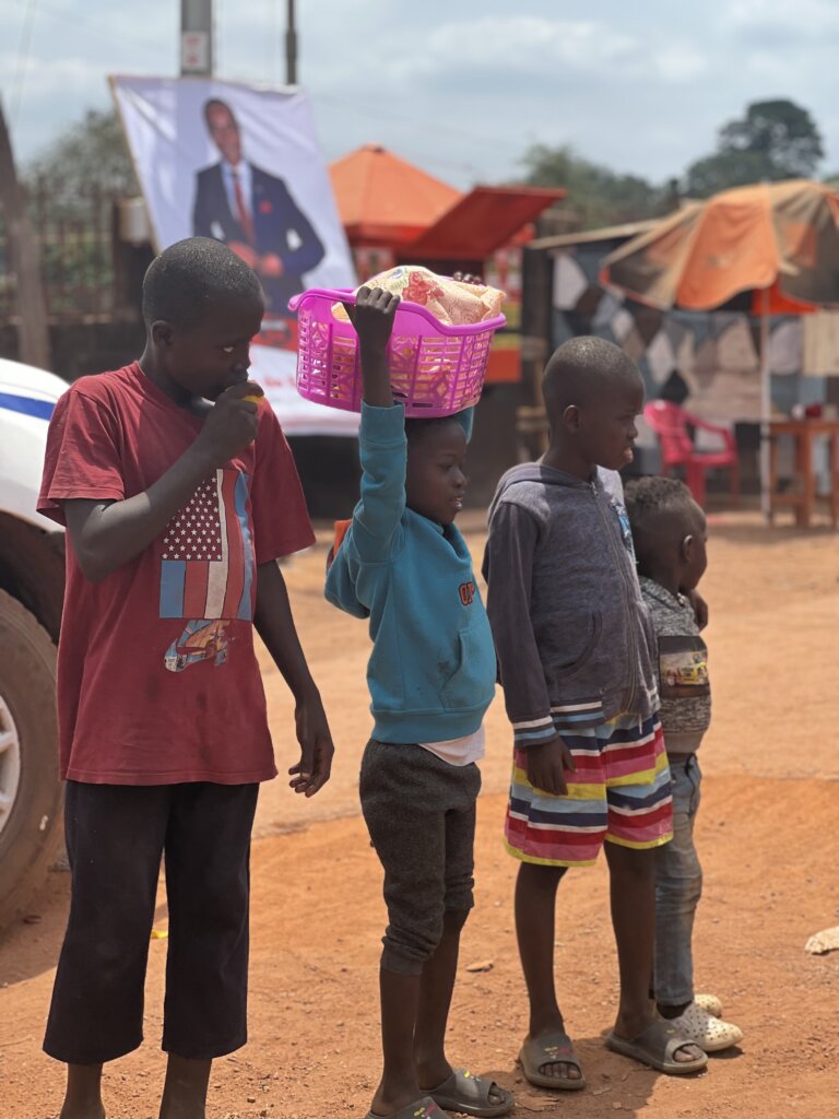 4 children hang about checking us out. One of them is carrying a basket on his head