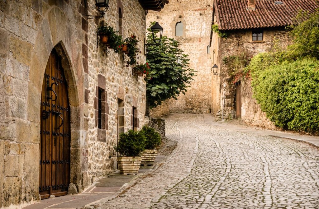 A cobbledstone street in Santillana del Mark with an old fashion wooden door