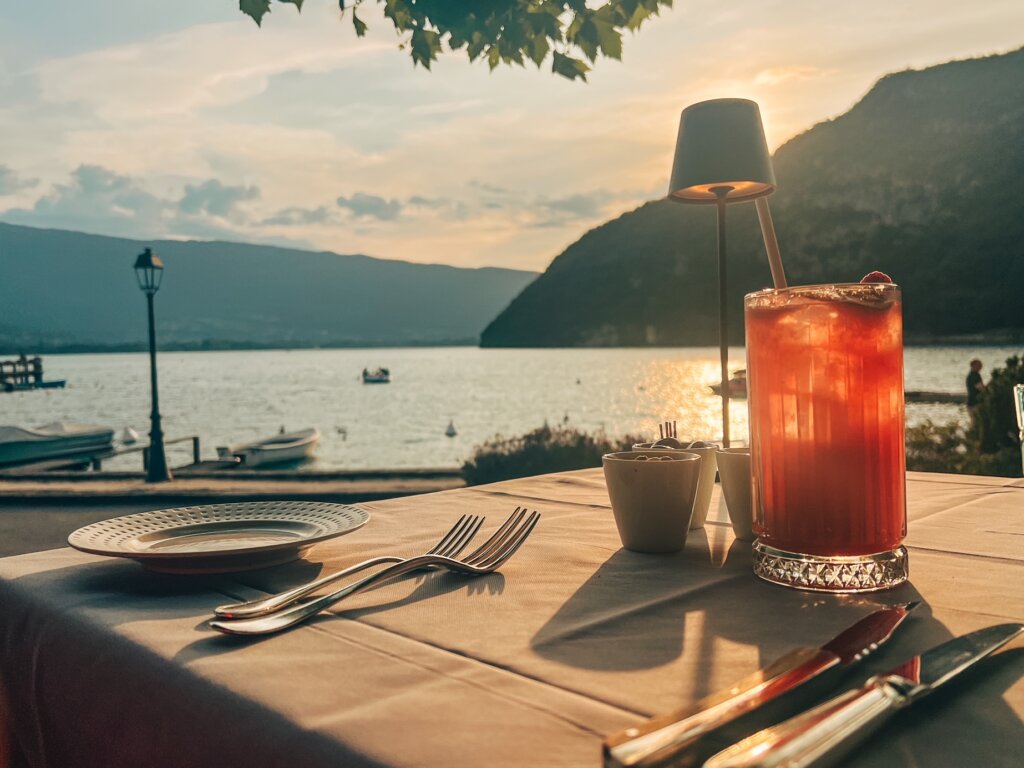 Sitting by Lake Annecy, cocktail in hand as the sun sets on a warm summer's evening, waiting for the gourmet meal to commence at Les Terrasses du Cottage