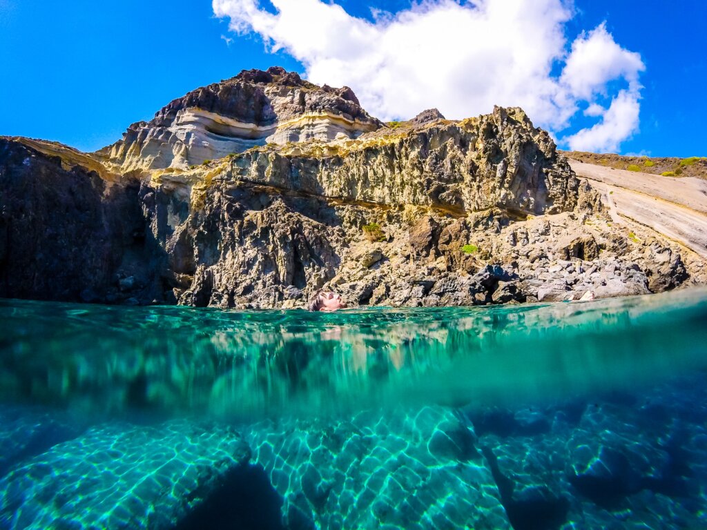 Interesting rock formations surrounded by turquoise blue clear water