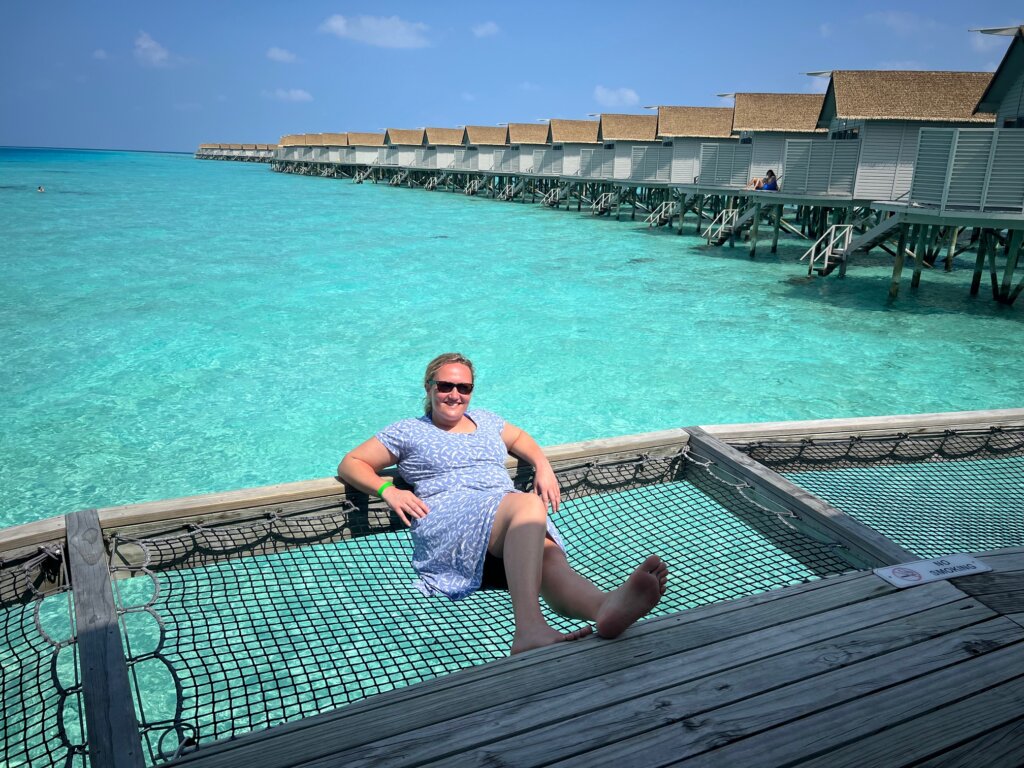 Bea chilling in the shade above the turquoise water with the water villas in the background