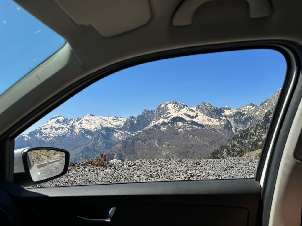 A mountain range as seen from the side window of a car