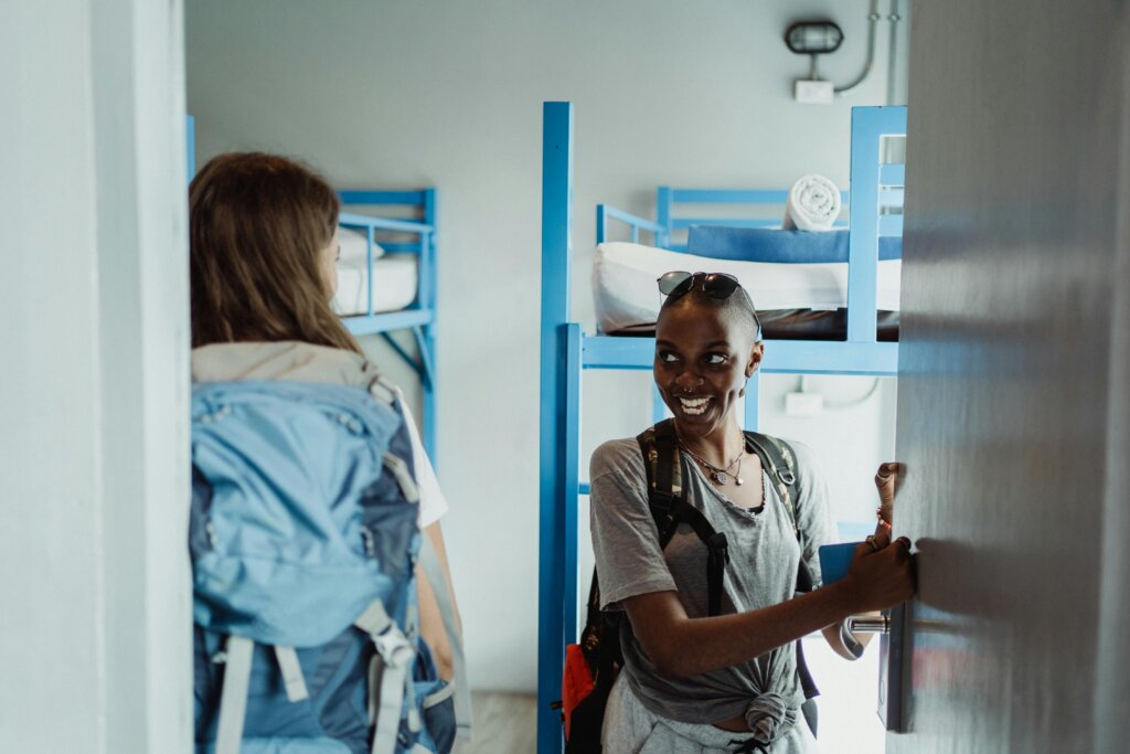 Two girls smiling as they enter the dorms of a hostel