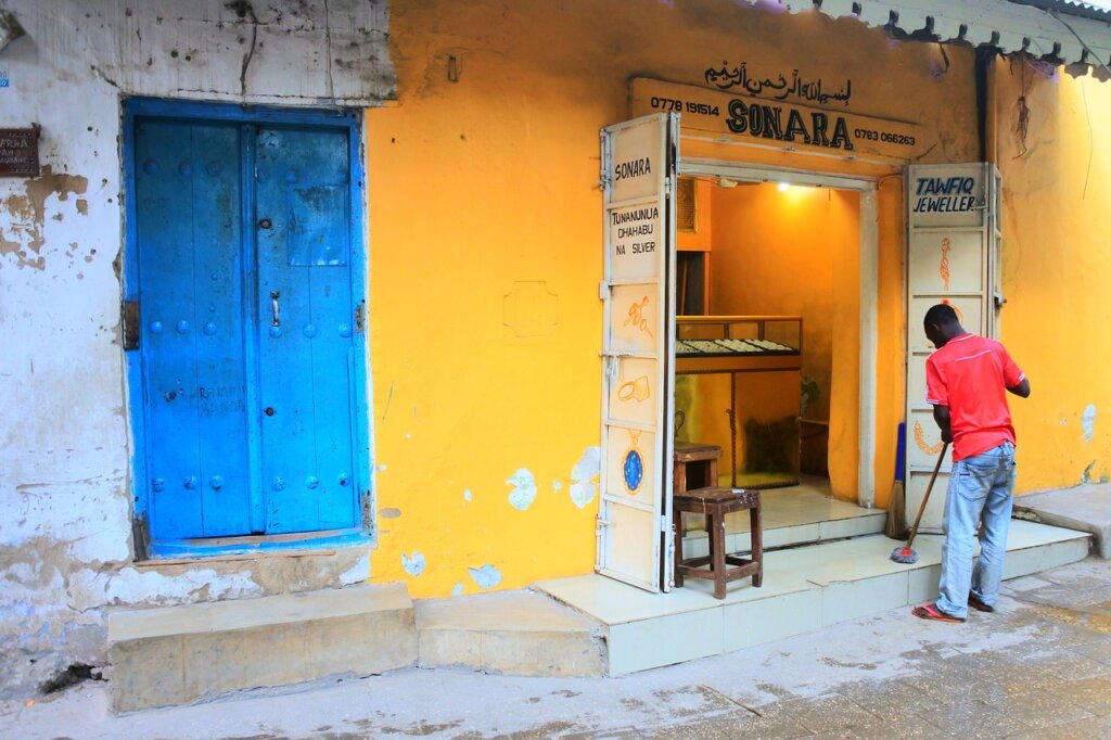 Man sweeps outside of his shop in Stonetown, Zanzibar