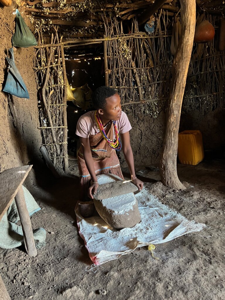 Datoga lady grinding maize