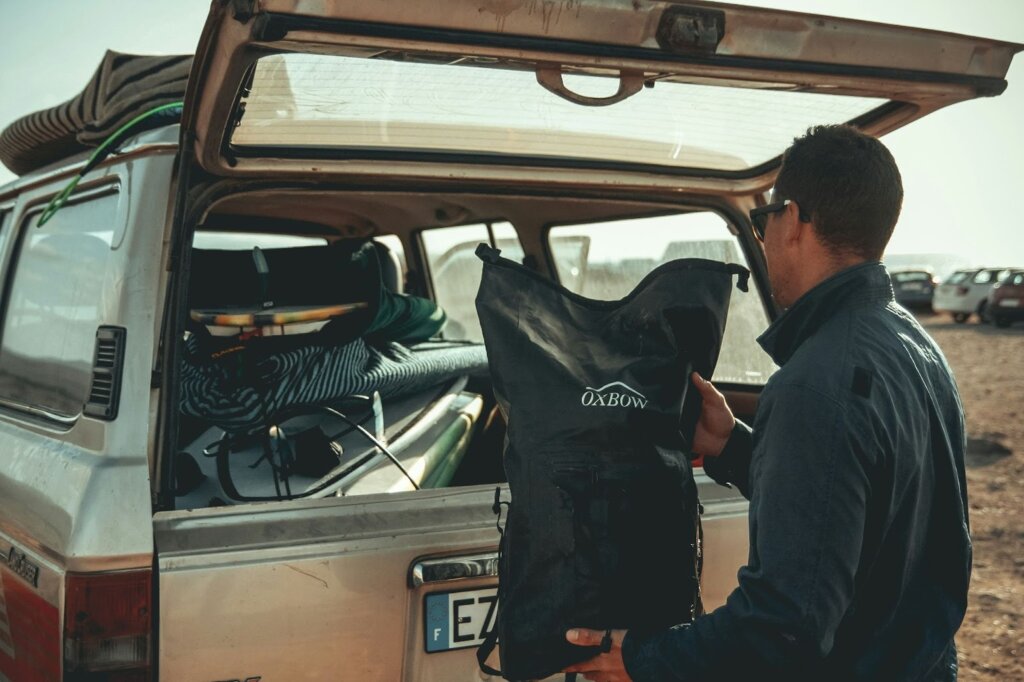 Alt text: Man loading gear into off-road vehicle.