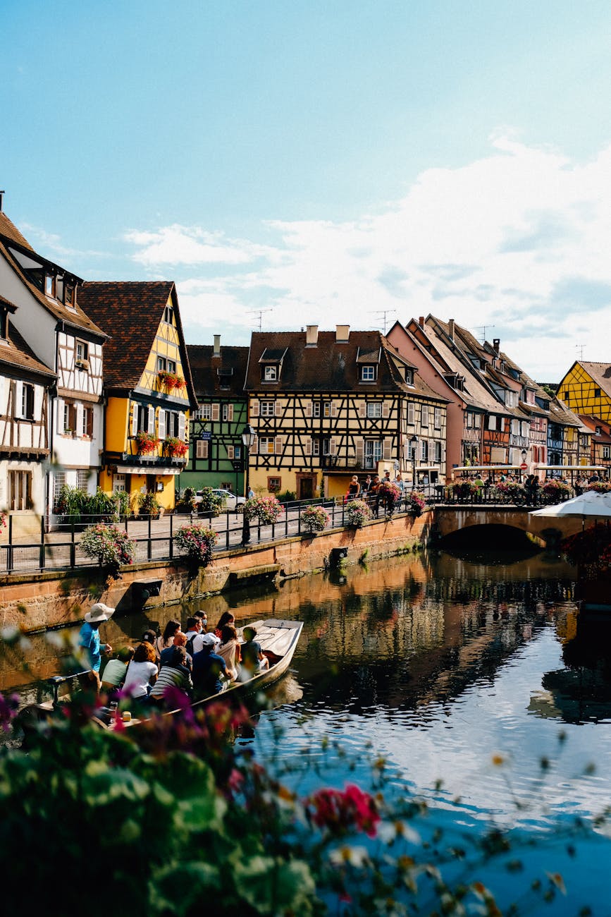tourists in boat floating on canal near old residential houses