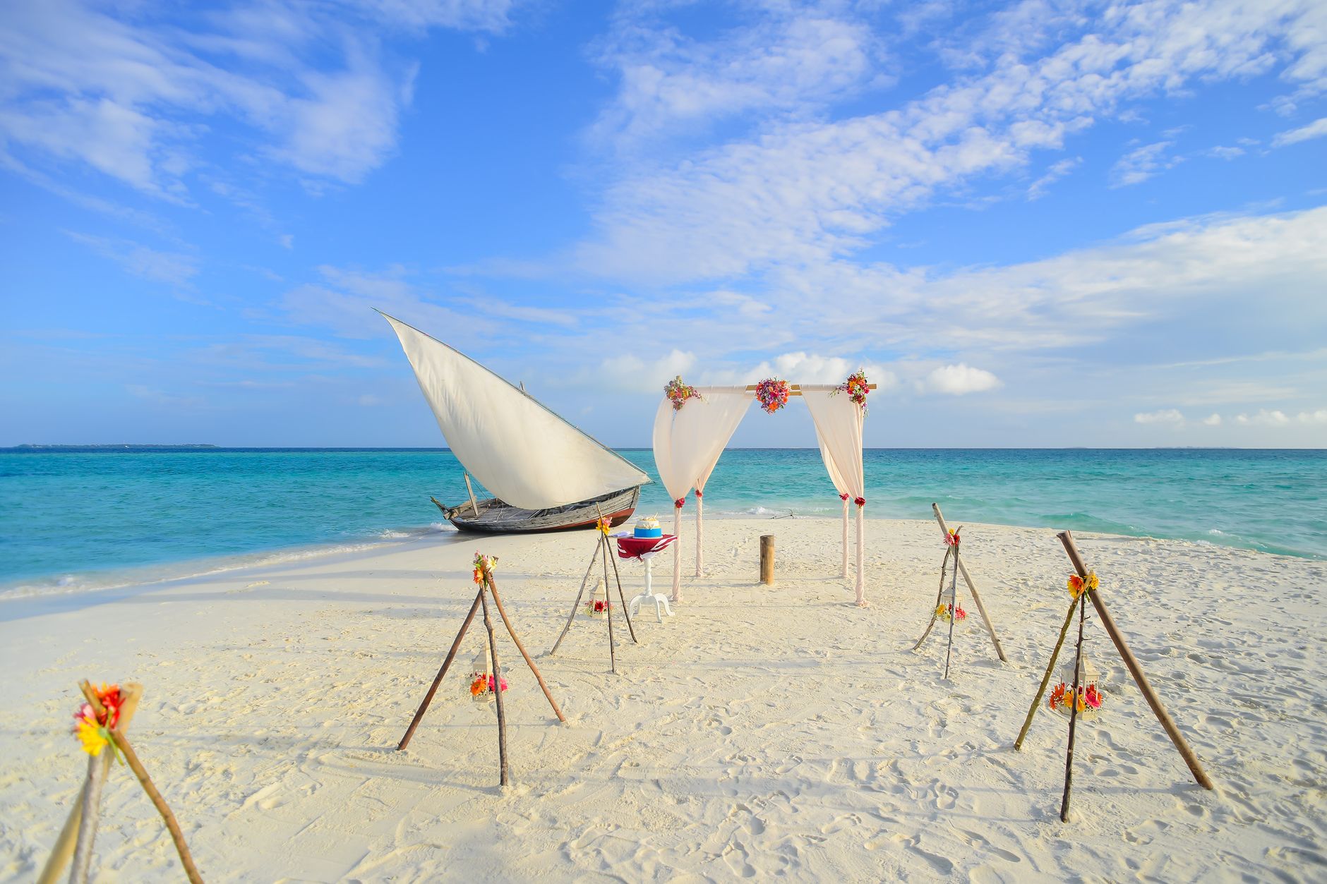 a beach occasion and white sail boat on shore